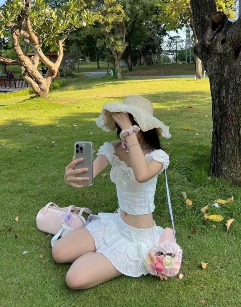 Ảnh gái xinh che mặt bằng tay trái ở bãi cỏ