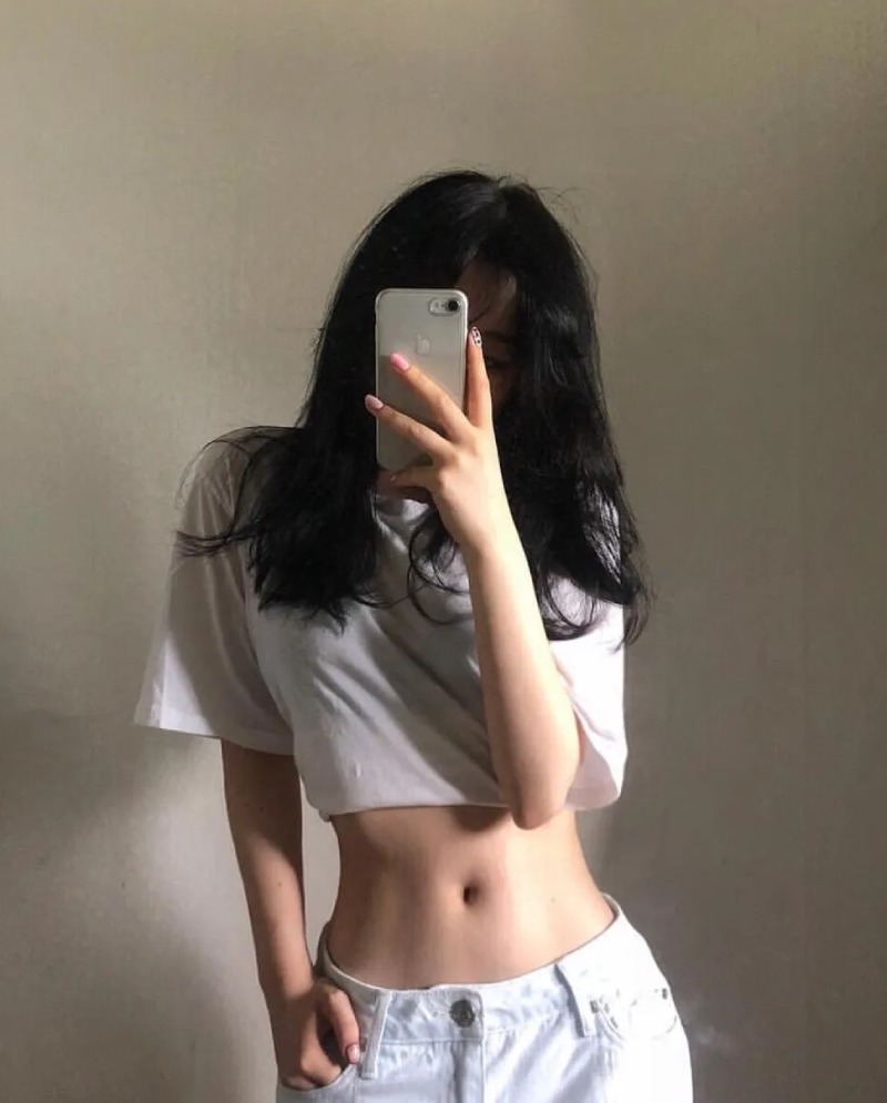 Ảnh gái xinh che mặt bằng điện thoại trước bức tường trơn