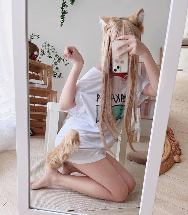 Gái xinh cosplay mèo vàng chụp dáng bằng điện thoại trước gương