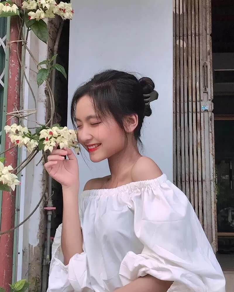 Ảnh gái xinh cute đứng ngửi hoa cười tươi