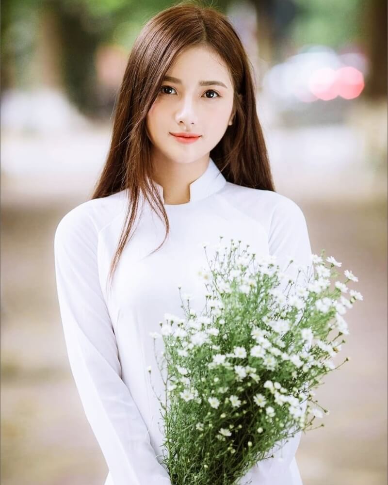 Ảnh gái xinh cute mặc áo dài trắng, tay cầm bó hoa