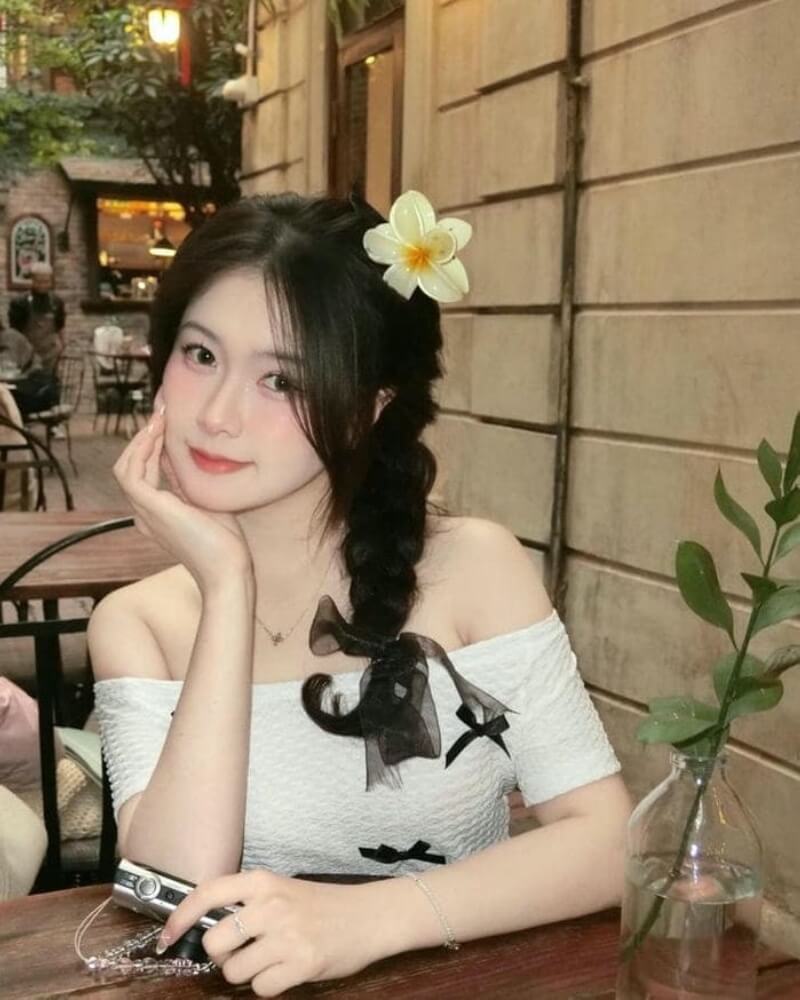 Ảnh gái xinh cute cài hoa lên tóc ngồi trong quán cà phê