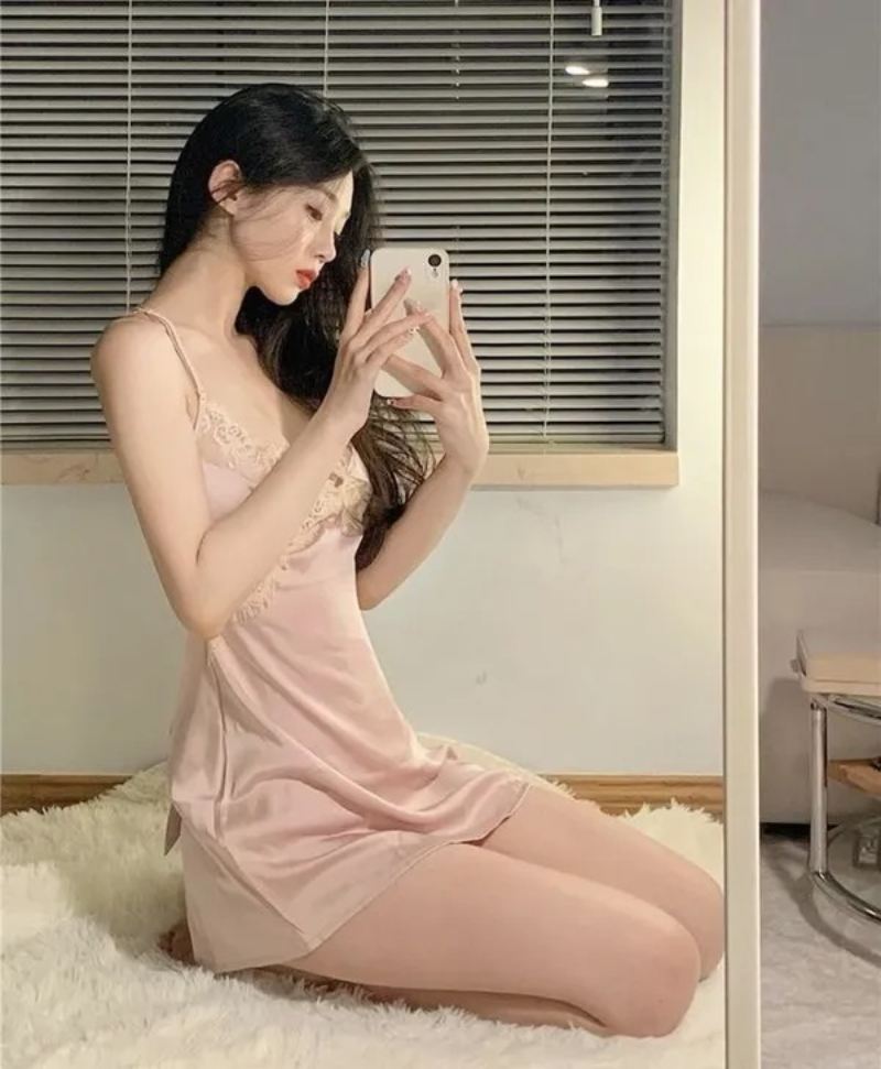 Ảnh gái xinh mặc đồ ngủ hồng ngồi chụp dáng bằng điện thoại trước gương