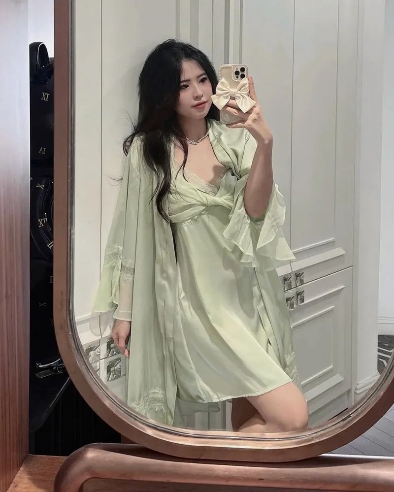 Ảnh gái xinh mặc đồ ngủ xanh đứng chụp dáng bằng điện thoại trước gương