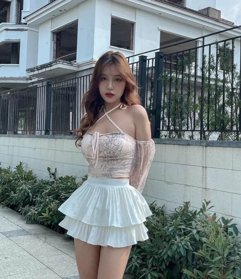 Ảnh gái xinh mặc váy ngắn xếp ly đứng trên đường