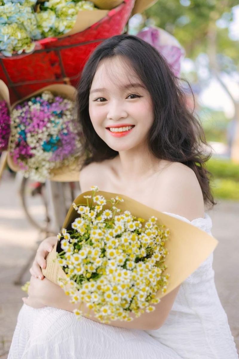 Ảnh gái xinh Việt Nam cười tươi, tay cầm bó hoa