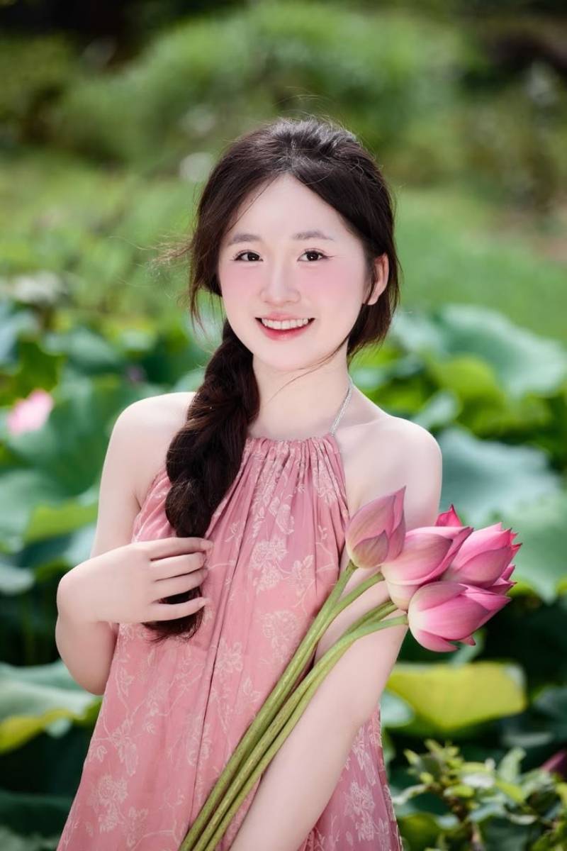 Ảnh gái xinh Việt Nam cầm hoa sen cười tươi