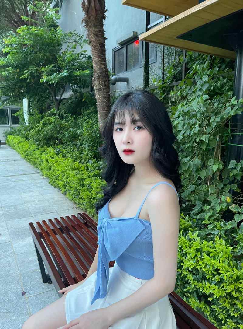 Ảnh Quỳnh Alee ngồi trên ghế ở sân vườn