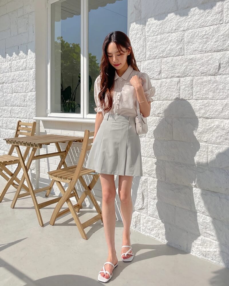 Gái xinh mặc váy ngắn đứng trước bức tường