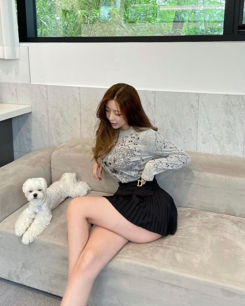 Ảnh gái xinh mặc váy ngắn xếp ly ngồi trên ghế sofa