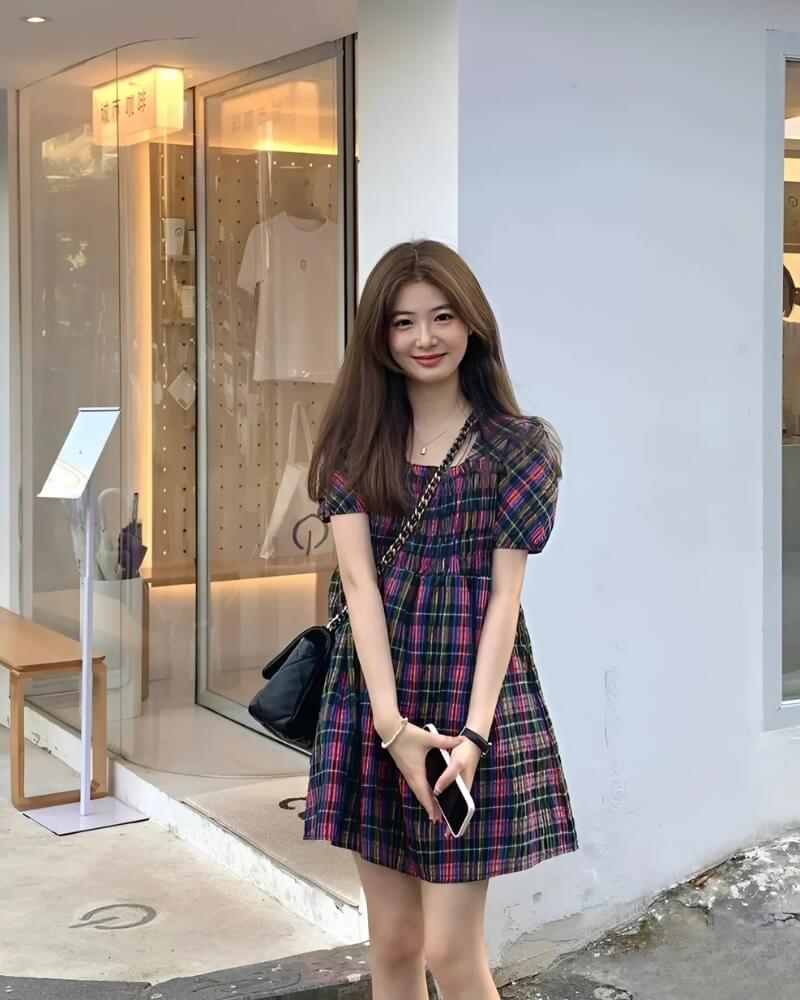 Gái xinh Trung Quốc mặc váy ngắn đứng trước bức tường nhà