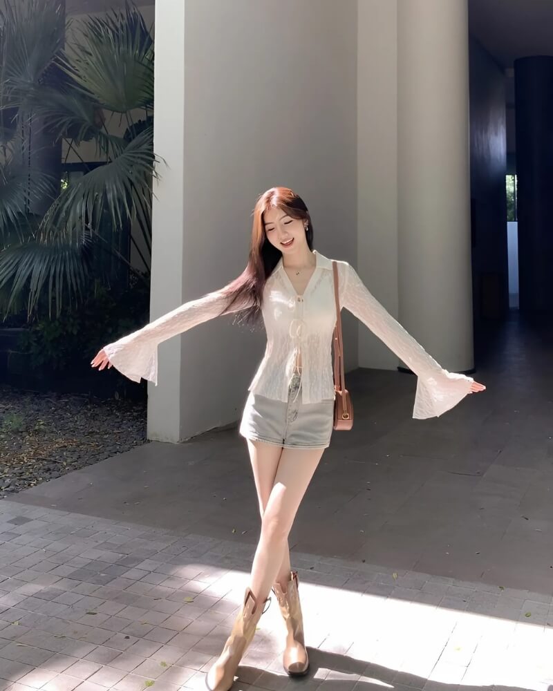 Gái xinh Trung Quốc mặc váy ngắn đứng dang hai tay trên sân