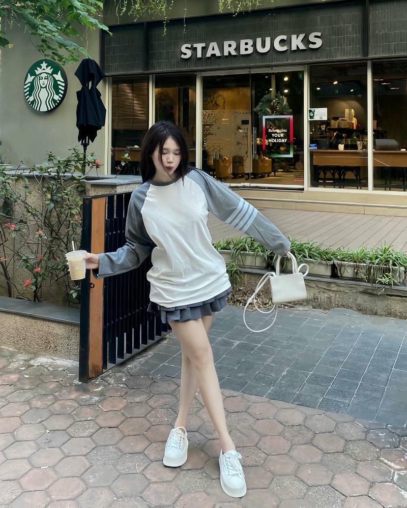 Gái xinh Trung Quốc mặc váy ngắn tạo dáng chéo chân trước quán starbucks