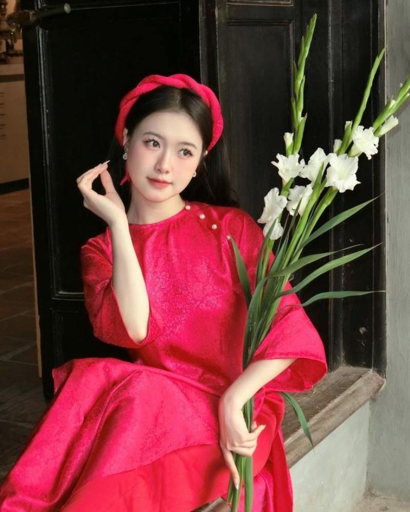 Gái xinh áo dài đỏ cầm nhánh hoa lay ơn trắng
