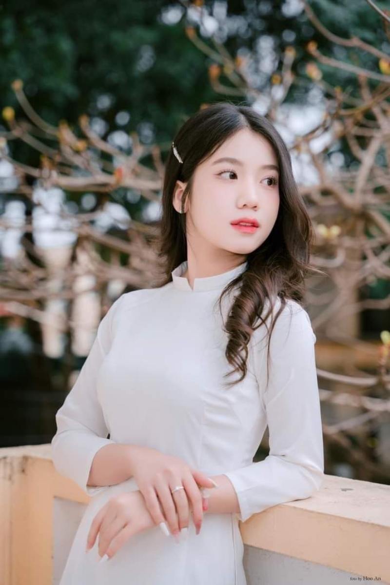 Gái xinh áo dài trắng tựa lưng vào lan can