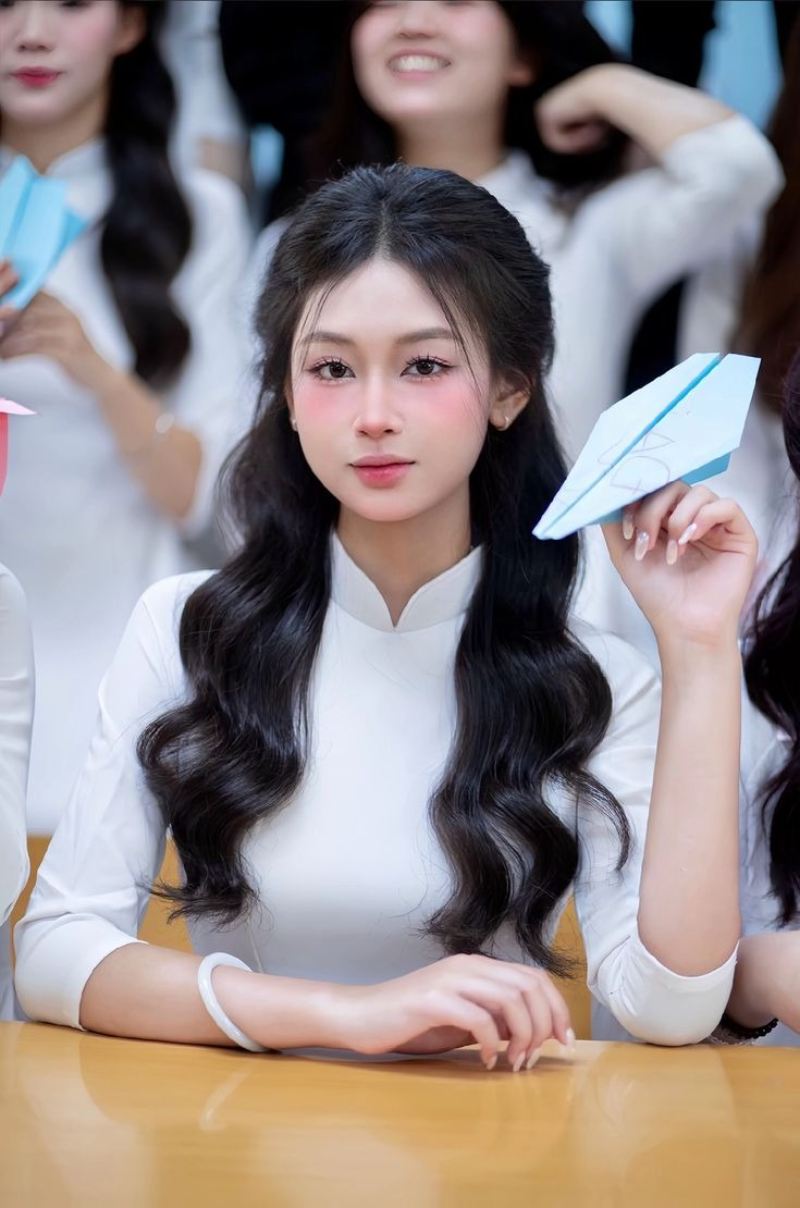 Gái xinh áo dài trắng chụp kỷ yếu tay cầm may bay giấy