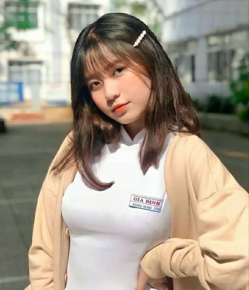 Gái xinh áo dài trắng đứng dưới sân trường