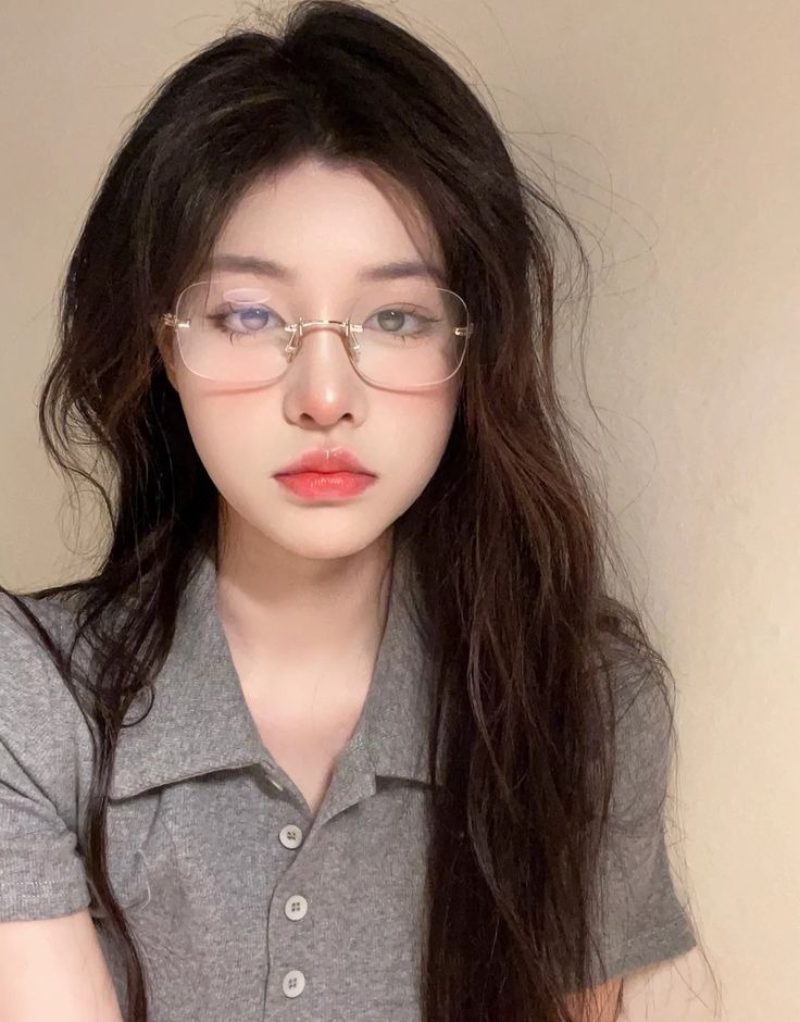 Ảnh gái xinh đeo kính trước bức tường trơn