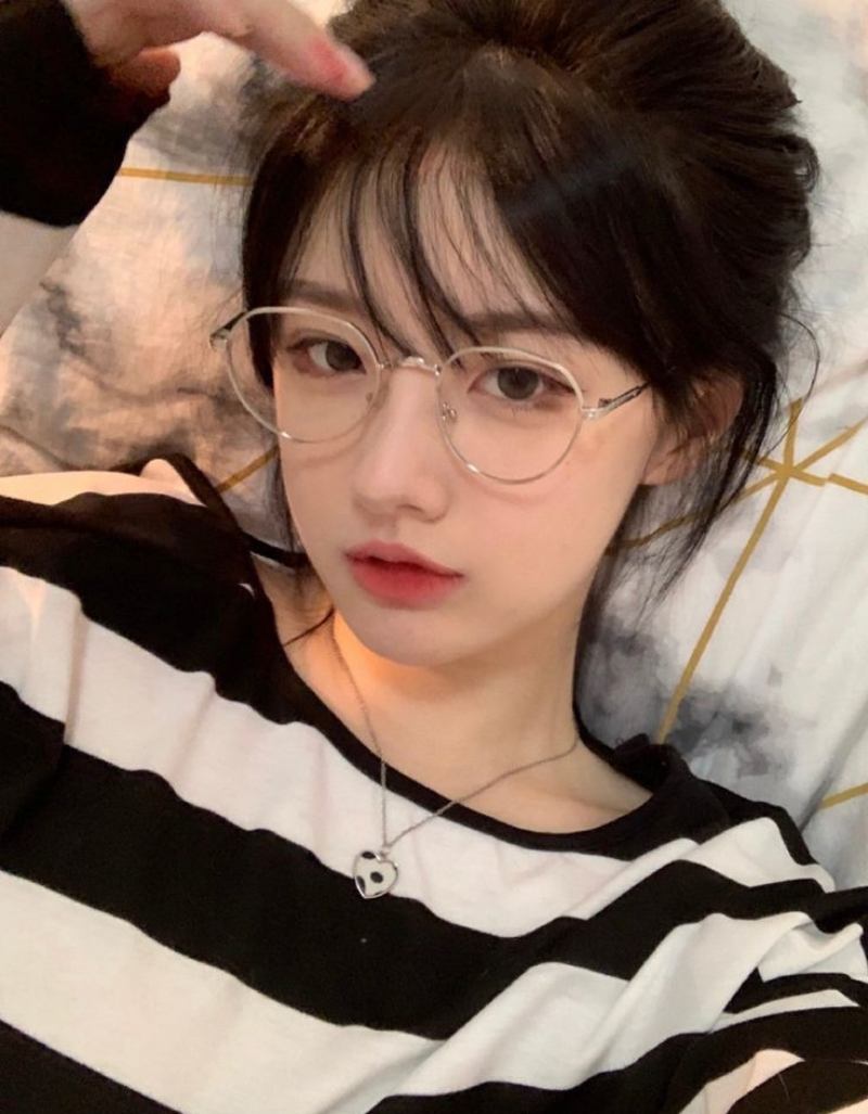 Ảnh gái xinh đeo kính nằm trên giường