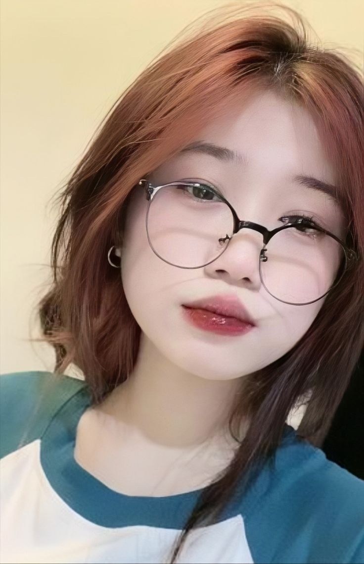 Ảnh gái xinh đeo kính trước bức tường trơn