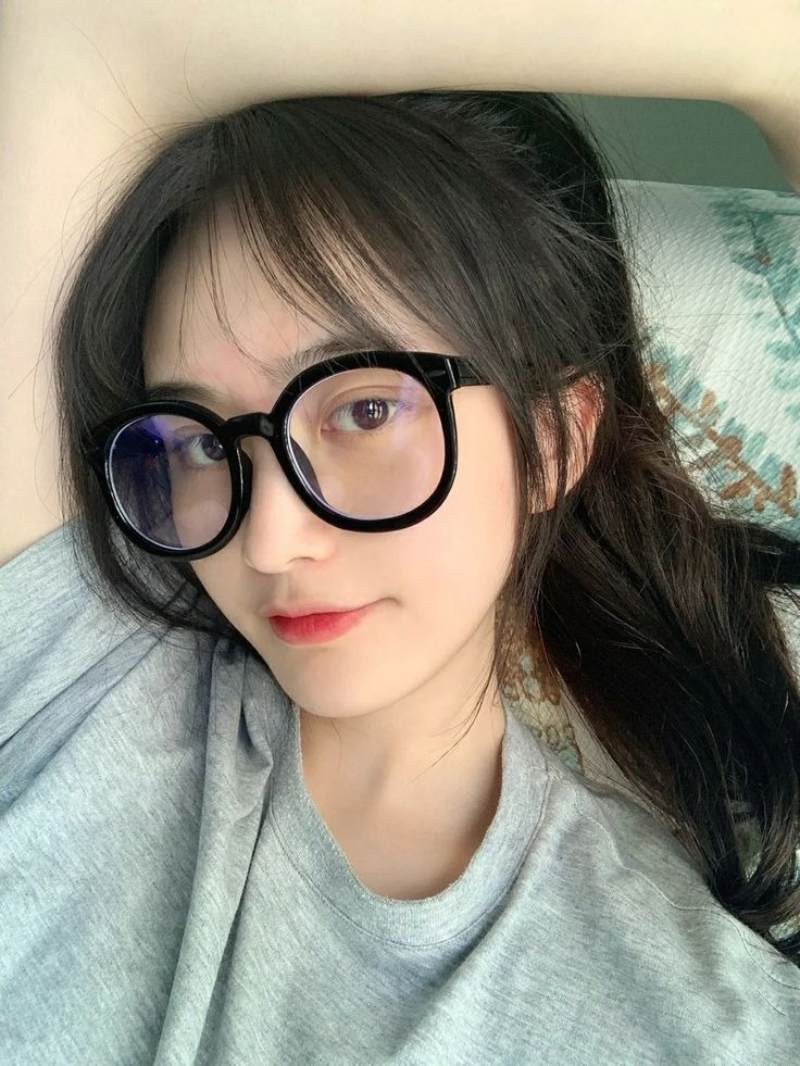 Ảnh gái xinh đeo kính nằm trên giường