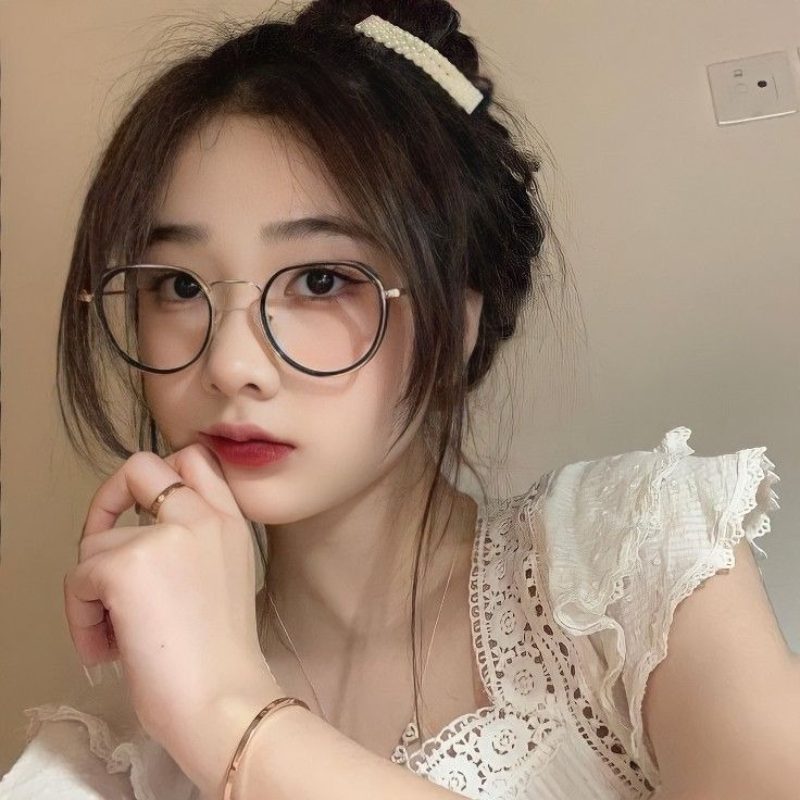 Ảnh gái xinh đeo kính trước bức tường trơn