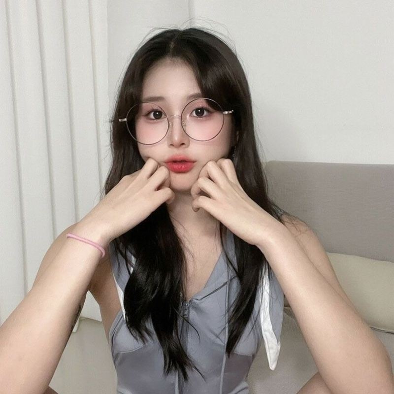 Ảnh gái xinh tóc dài đeo kính ngồi trên giường
