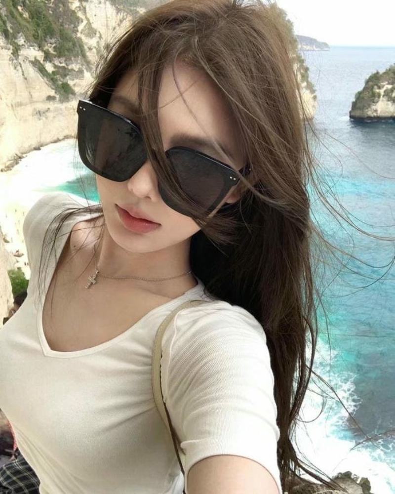 Ảnh gái xinh tóc dài đeo kính đen ở bờ biển