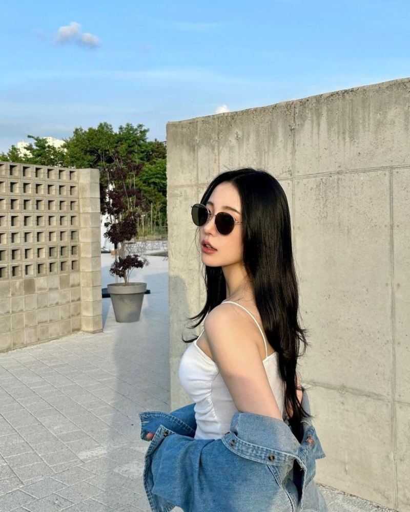 Ảnh gái xinh tóc dài đeo kính đen trong sân nhà