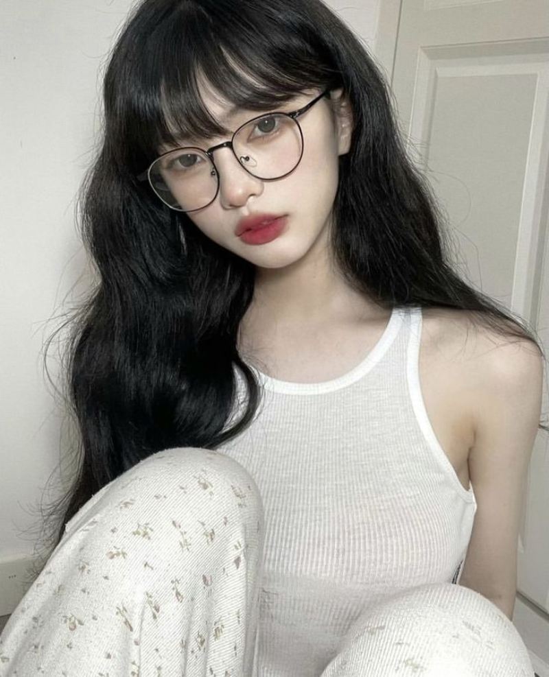 Ảnh gái xinh tóc dài đeo kính trước cánh cửa