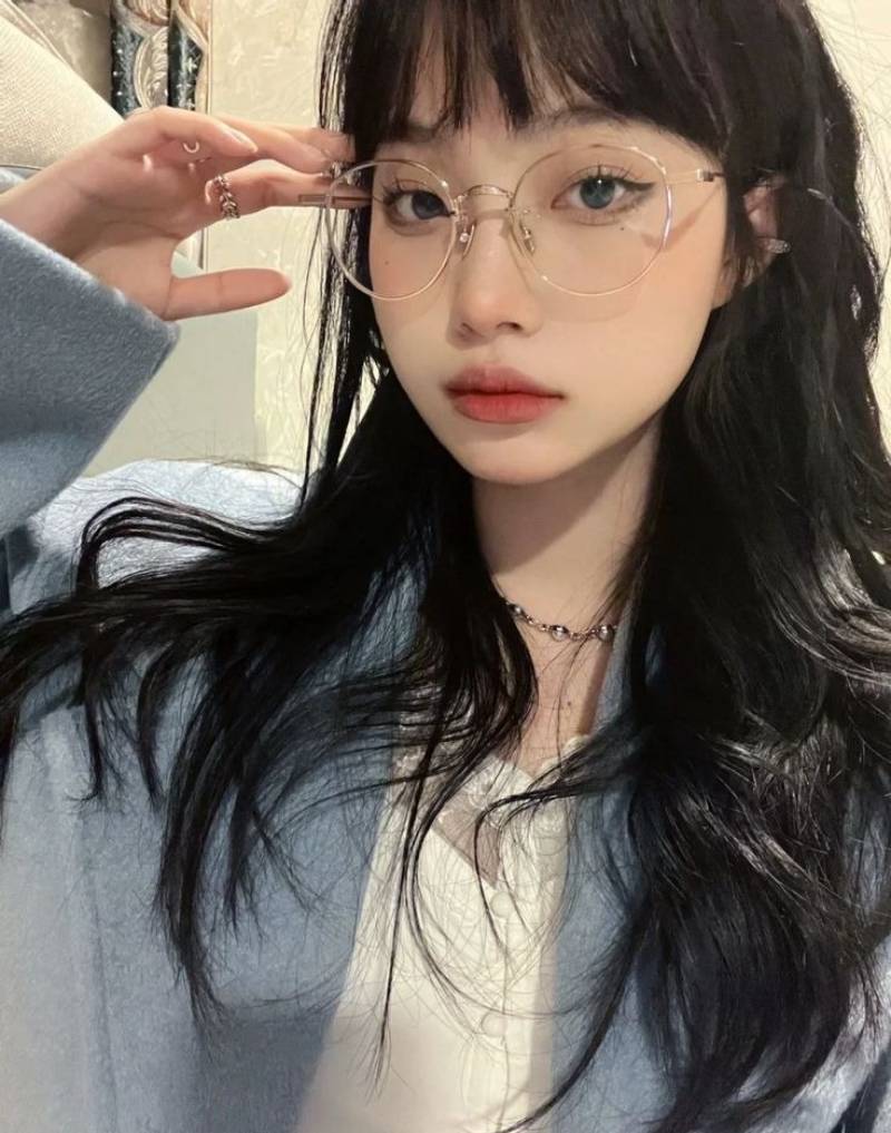 Ảnh gái xinh tóc dài đeo kính tay phải chạm gọng kính