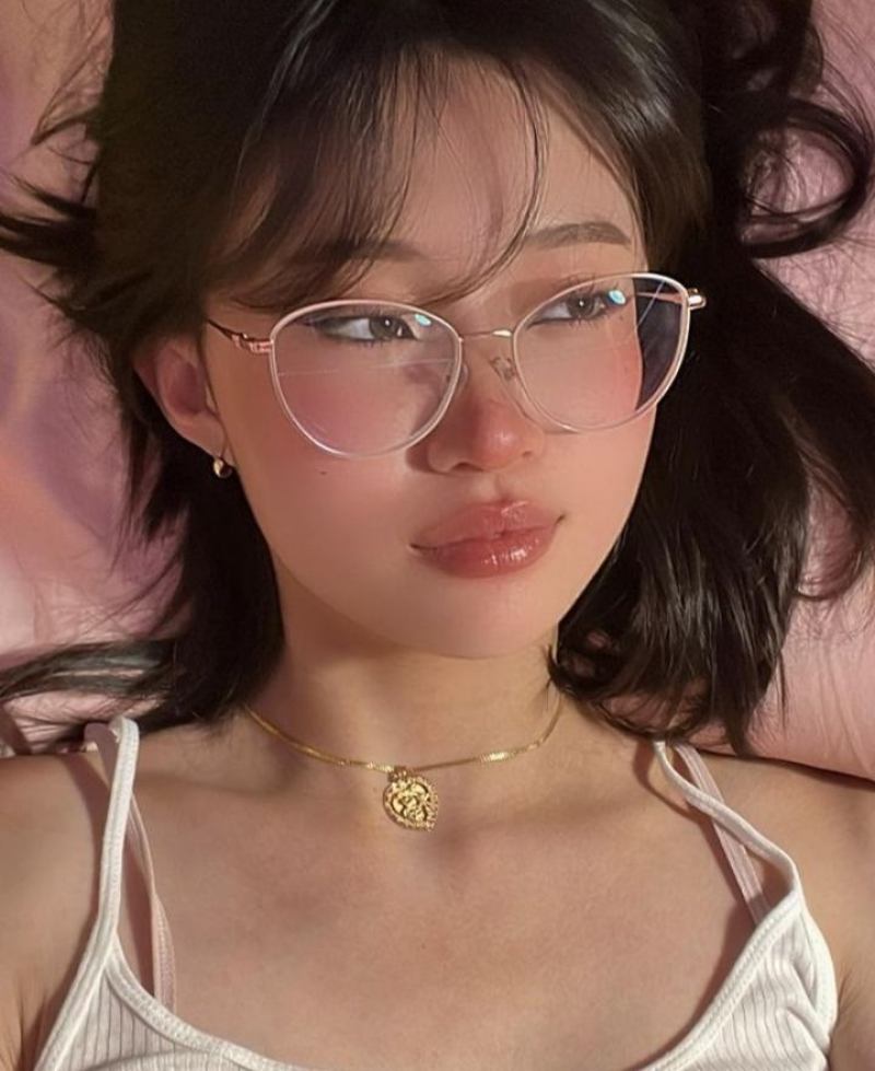 Ảnh gái xinh tóc dài đeo kính nằm ngửa trên giường