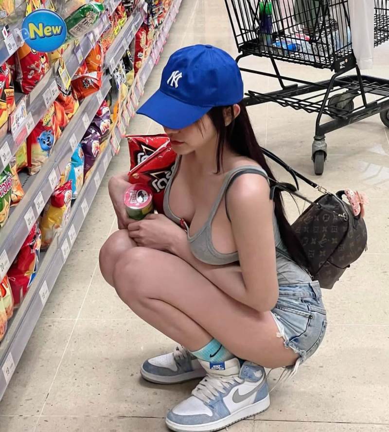 Gái xinh mặc đồ hở hang lộ ngực to ngồi bên cạnh kệ hàng siêu thị