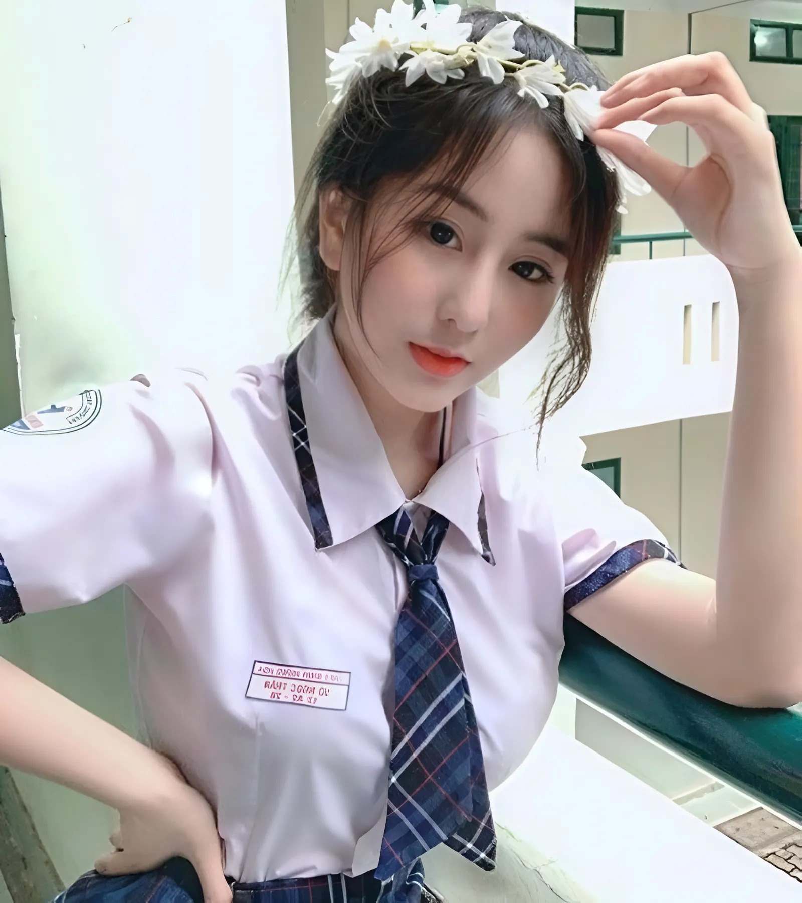 Gái xinh 2k8 mặc áo trắng, đeo vòng hoa đứng bên lan can Gái xinh 2k8 mặc áo trắng, đeo vòng hoa đứng bên lan can