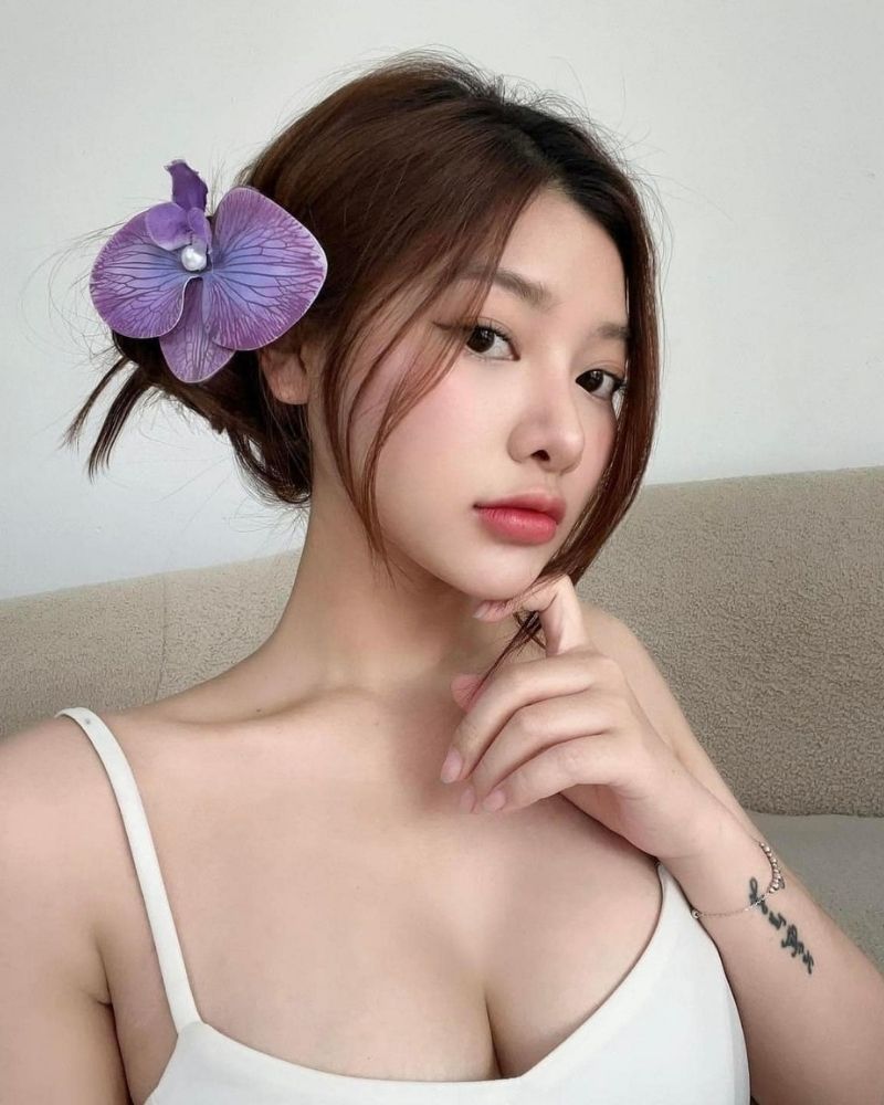 Ảnh gái xinh tự sướng tay trái chạm cằm, tóc cài hoa