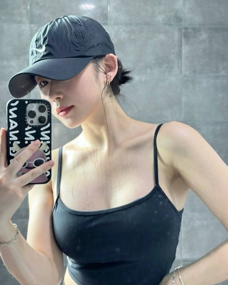 Ảnh gái xinh tự sướng trước gương, tay cầm điện thoại, đội mũ