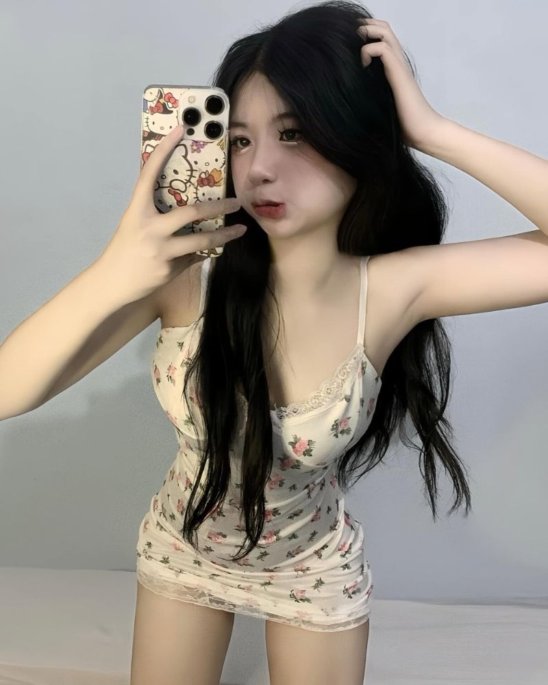 Ảnh gái xinh tự sướng mặc đồ ngủ, tay phải cầm điện thoại