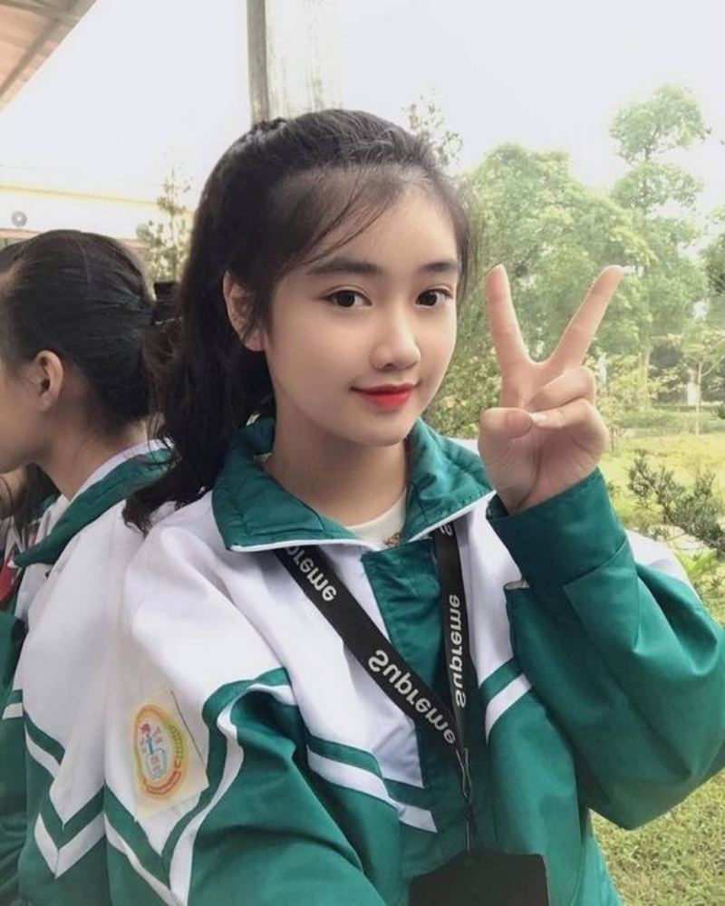 Ảnh gái học sinh mặc áo khoác đồng phục chào chữ V Ảnh gái học sinh mặc áo khoác đồng phục chào chữ V