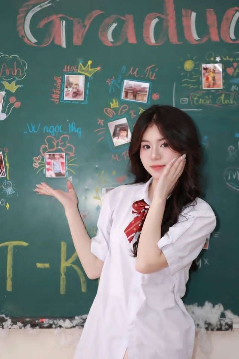 Gái học sinh mặc áo sơ mi trắng đứng trước bảng lớp học Gái học sinh mặc áo sơ mi trắng đứng trước bảng lớp học