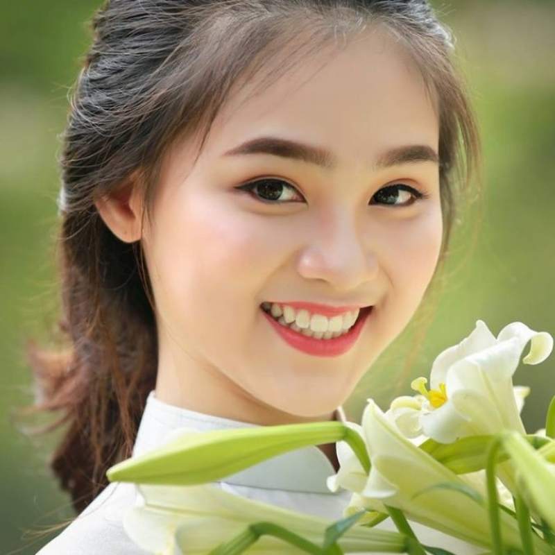 Ảnh gái xinh cười tươi cầm hoa loa kèn Ảnh gái xinh cười tươi cầm hoa loa kèn
