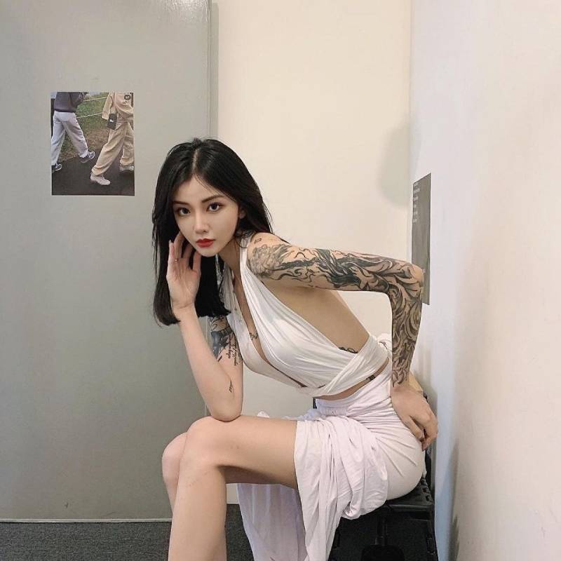 Gái xăm hình mặc đồ hở hang ngồi trên ghế