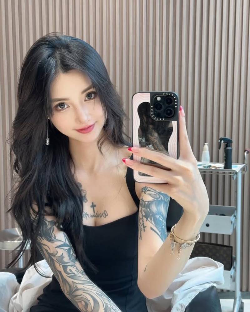 Gái xăm hình kín tay ngồi chụp dáng bằng điện thoại