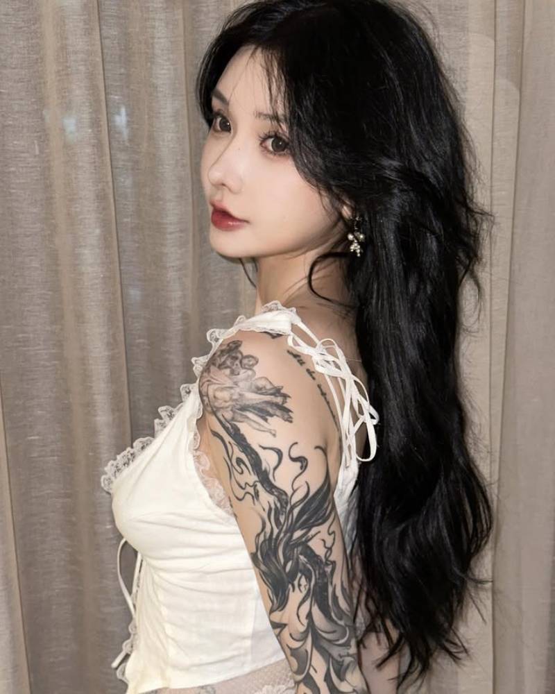 Gái xăm hình kín tay đứng quay nghiêng người